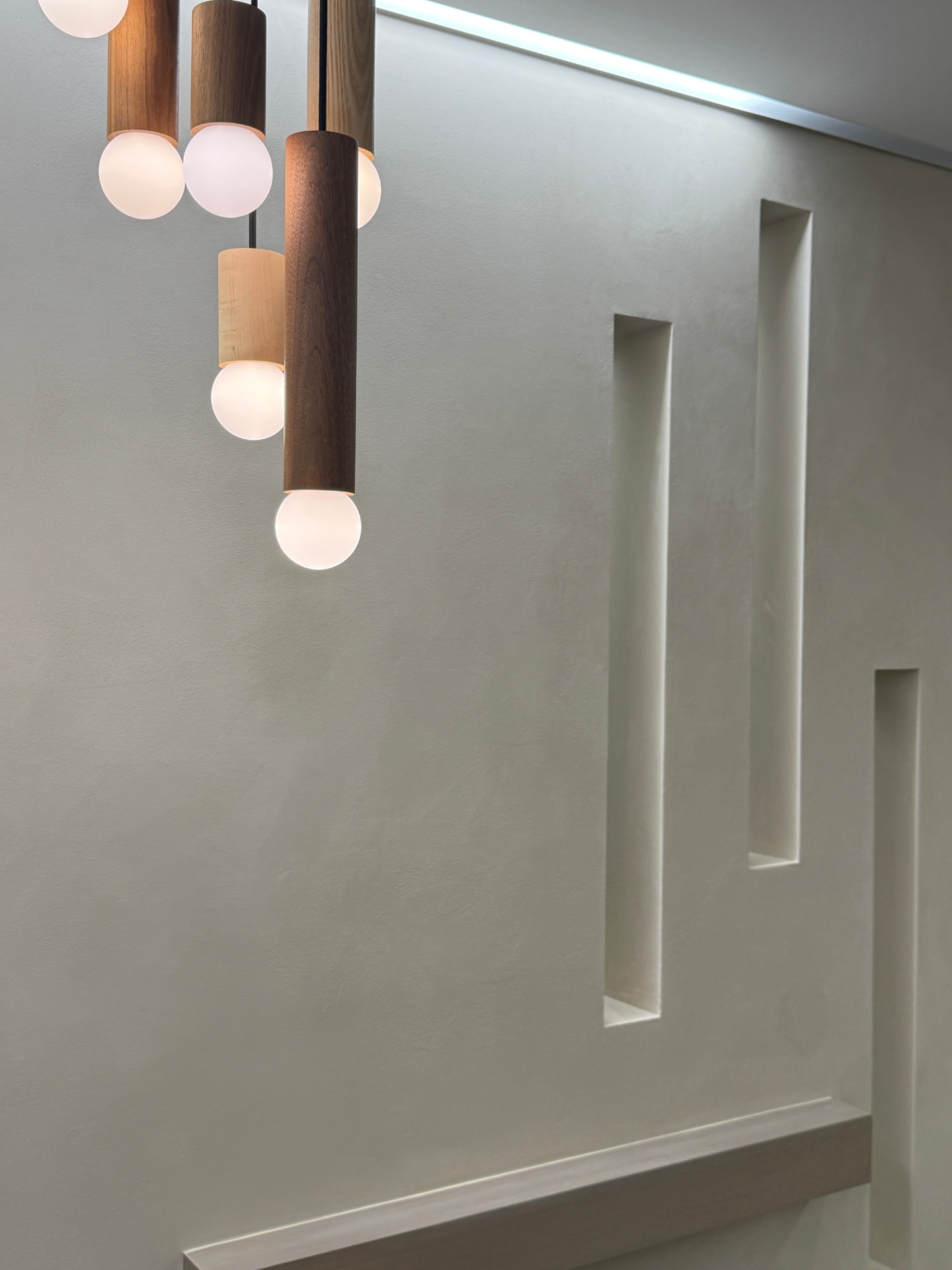 Curved recovery nook with pendant lights over hand-troweled limewash.