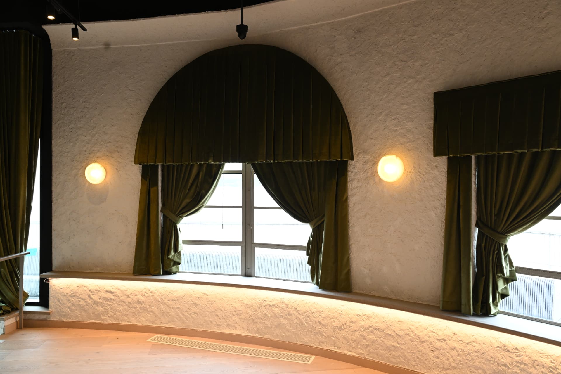 Textured plaster wall framing the arched window.